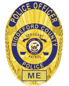 A police badge with text and a blue and white circle