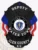 A custom metal badge in black featuring the title "DEPUTY" prominently at the top, above a central eagle emblem. The badge displays the words "COMM. OF MASSACHUSETTS" and "WATER TOWN" in bold letters. Below the state seal, it reads "GLEN COUNTY" and "K9." The badge is adorned with decorative blue and red elements, enhancing its design. The matte black finish gives the badge a sleek and authoritative appearance, emphasizing its significance in law enforcement.