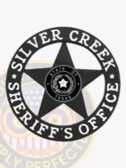 A custom metal badge in black color with safety pin attachment, designed in the shape of a star. The badge features "SILVER CREEK" and "SHERIFF'S OFFICE" in bold white lettering around the edge. In the center, it displays the state emblem of Texas, featuring a star within a circular design. This badge conveys a professional and authoritative appearance, ideal for law enforcement personnel.