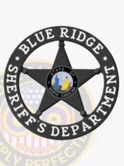 A custom metal badge in black color with safety pin attachment, shaped like a star. The badge prominently features "BLUE RIDGE" and "SHERIFF'S DEPARTMENT" in bold white lettering around the edge. In the center, it displays the state emblem of North Carolina, showcasing colorful figures, enhancing its professional and authoritative look for law enforcement personnel.