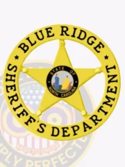 A custom metal badge in gold color with safety pin attachment, shaped like a star in a circle banner. The badge displays "BLUE RIDGE" and "SHERIFF'S DEPARTMENT" in bold black lettering around the perimeter. In the center, it features the state emblem of North Carolina, showcasing a colorful design. This badge is designed to convey authority and professionalism for law enforcement personnel.