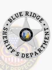 A custom metal badge in silver color with safety pin attachment, shaped like a star. The badge features "BLUE RIDGE" and "SHERIFF'S DEPARTMENT" in bold black text around the edge. In the center, it showcases the emblem for the state of North Carolina, depicting colorful figures, giving it a distinctive and professional appearance for law enforcement personnel.